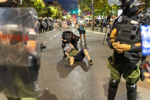 A Serbian police officer detains a person, during a standoff between supporters of the ruling party and anti-government protesters in Belgrade, Serbia, August 14, 2025. REUTERS/Djordje Kojadinovic