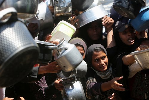 Palestinians wait to receive food from a charity kitchen, amid a hunger crisis, in Khan Younis, southern Gaza Strip, August 4, 2025.