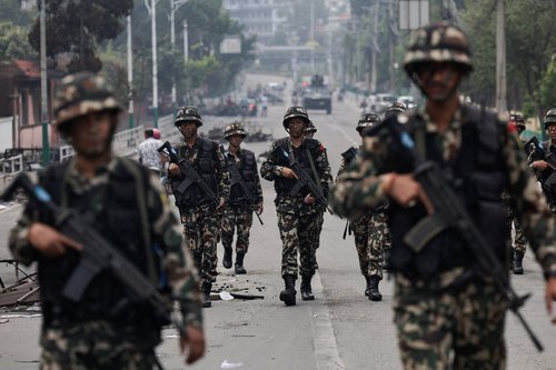 Nepali army soldiers patrol at the road near the Singha Durbar office complex that houses the Prime Minister's office