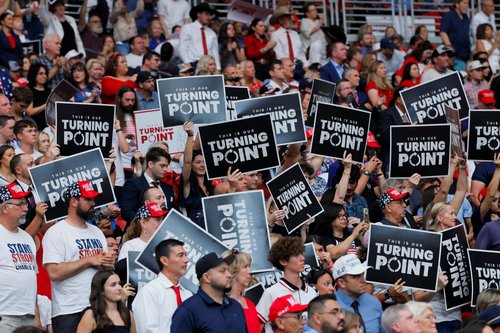 People raise placards reading "This is our Turning Point" during a memorial service for slain conservative commentator Charlie Kirk