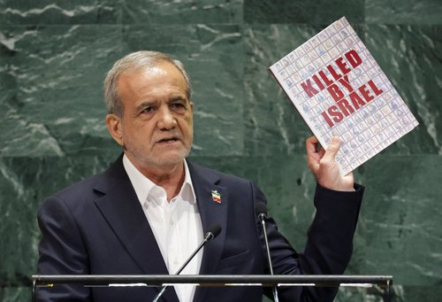 Iran's President Masoud Pezeshkian shows a book as he addresses the 80th United Nations General Assembly (UNGA) at the U.N. headquarters in New York, U.S., September 24, 2025.