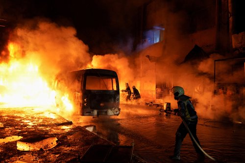 Members of the Syrian Civil Defence work to extinguish a fire after shelling amid renewed clashes between the Syrian army and the Syrian Democratic Forces in Aleppo