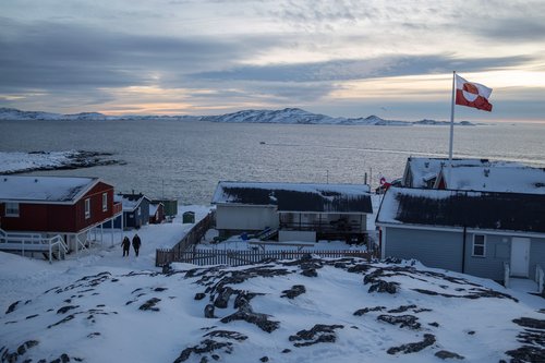 A Greenland flag flies as people walk on the day of a meeting between top U.S. officials and the foreign ministers of Denmark and Greenland, in Nuuk, Greenland, January 14, 2026. REUTERS/Marko Djurica