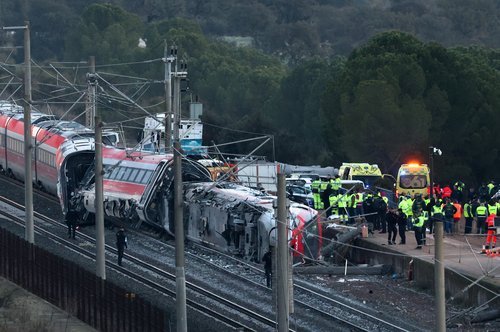 Members of the Spanish Civil Guard along with other emergency personnel work next to one of the trains involved in the accident, at the site of a deadly derailment of two high-speed trains near Adamuz, in Cordoba, Spain