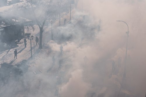 Federal agents walk through a massive cloud of teargas near the site where a man identified as Alex Pretti was fatally shot by federal agents trying to detain him, in Minneapolis, Minnesota, U.S., January 24, 2026.REUTERS/Tim Evans
