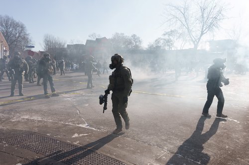 Federal agents walks through a cloud of teargas near the site where a man identified as Alex Pretti was fatally shot by federal agents trying to detain him, in Minneapolis, Minnesota, U.S., January 24, 2026.REUTERS/Tim Evans