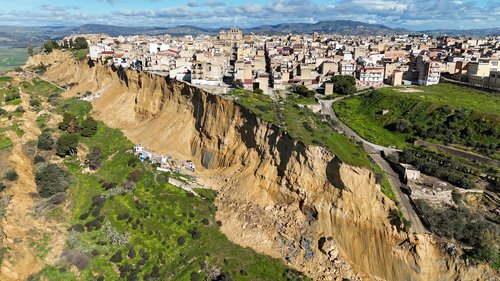 A drone picture shows houses perched along the edge of a cliff after a landslide in Niscemi, Sicily, Italy, January 27, 2026. REUTERS/Danilo Arnone REFILE - QUALITY REPEAT
