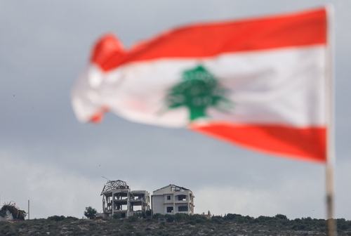 A Lebanese flag flies as buildings lie in ruins in Mansouri, as seen from Henniye, Lebanon, September 29, 2026.