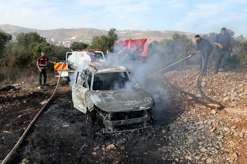 A Palestinian man douses a burning car with water after Israeli militant settlers attacked a group of Palestinians harvesting olives near Turmus Ayya in the Israeli-occupied West Bank, October 16, 2026.