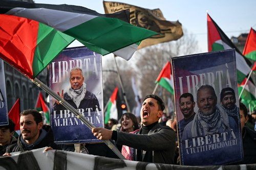 Demonstrators wave Palestinian flags and hold banners depicting Mohammad Hannoun, president of the Palestinian Association in Italy, who was arrested by Italian authorities