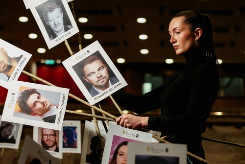 A model poses while holding place sticks for guests during preparations for the British Academy of Film and Television Arts (BAFTA) award ceremony at the Royal Festival Hall in London, Britain, February 16, 2026. REUTERS/Corey Rudy