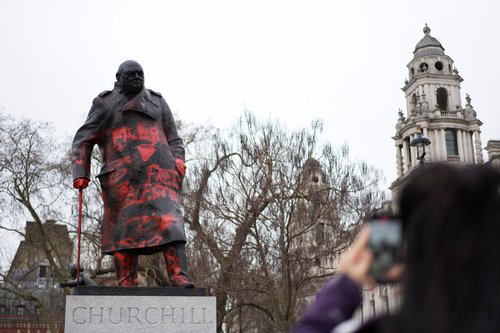 A woman takes photos of the statue of Sir Winston Churchill in Parliament Square, which has been defaced overnight with red paint and the words 'Free Palestine', in London, Britain, February 27, 2026.