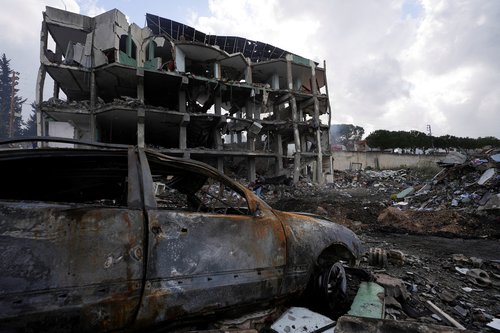 A damaged car near a damaged building in the aftermath of an Israeli strike on a healthcare center, where, according to a Lebanese state news agency report citing the country's Health Ministry, multiple members of medical personnel were killed