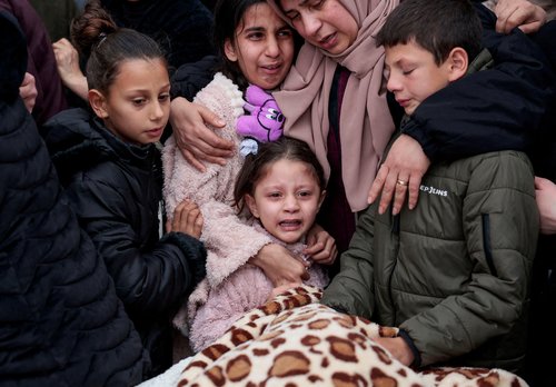 A child cries as mourners carry the bodies of a Palestinian family, the parents and their two children, who were killed in an Israeli raid, during their funeral in Tammoun town near Tubas