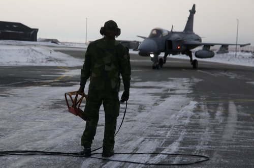 A Swedish ground crew member watches as a JAS 39 Gripen approaches on the tarmac at the air base in Keflavik, Iceland, March 3, 2026.