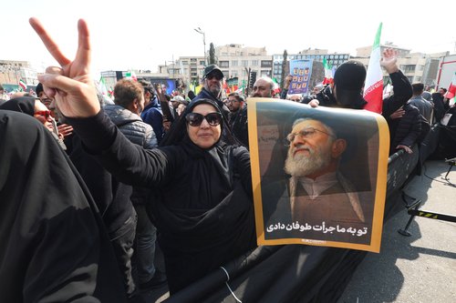A woman holds a poster of Iran's late Supreme Leader Ayatollah Ali Khamenei, who was killed in airstrikes, during the funeral of Iranian security chief Ali Larijani and victims of the IRIS Dena warship at Enghelab Square