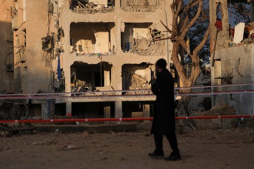 A man stands at the scene of damage after Iranian missile barrages struck residential buildings in Arad, amid the U.S.-Israel conflict with Iran, in southern Israel, March 22, 2026. REUTERS/Ronen Zvulun