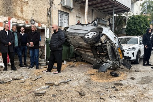 People gather at the missile impact site, after Iranian missile barrages were launched at Israel, amid the U.S.-Israel conflict with Iran, in central Israel, March 26, 2026.