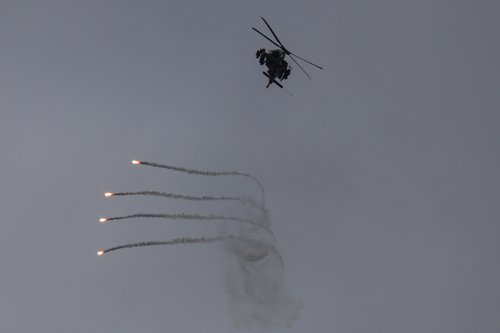 An Israeli helicopter releases flares, near the Israel-Lebanon border, as seen from the Israeli side of the border in northern Israel