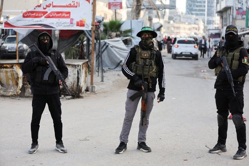 Militants from Hamas and Palestinian Islamic Jihad stand on a street during Eid al-Fitr in Gaza City, March 20, 2026.