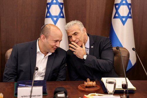 FILE PHOTO: Israel's caretaker Prime Minister Yair Lapid speaks with former prime minister Naftali Bennett during the weekly cabinet meeting in Jerusalem, September 18, 2022. Ronaldo Schemidt/Pool/File Photo