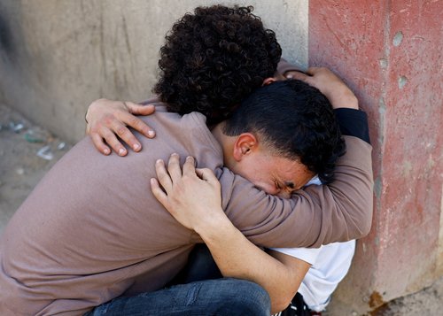 Palestinians react following an Israeli strike outside a school sheltering displaced people, according to medics, at Al-Aqsa Martyrs Hospital in Deir al-Balah in the central Gaza Strip, April 6, 2026.