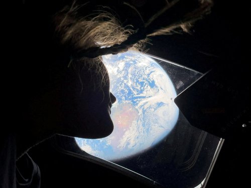 NASA astronaut and Artemis II mission specialist Christina Koch peers out of one of the Orion spacecraft's main cabin windows, looking back at Earth, as the crew travels towards the Moon April 2, 2026.
