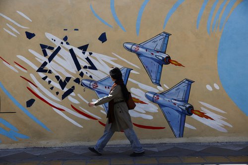 A woman walks next to an anti-Israeli mural on a street after U.S. President Donald Trump said that he had agreed to a two-week ceasefire with Iran, in Tehran, Iran, April 8, 2026.