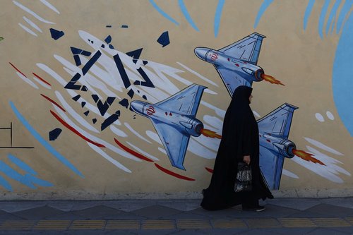An Iranian woman walks next to an anti-Israeli mural on a street in Tehran, Iran, May 18, 2026.
