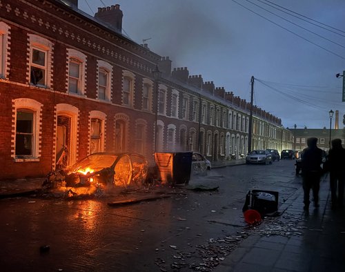 A car burns in east Belfast, during a protest after a knife attack on June 8 left a man seriously injured and prompted police to declare a critical incident, in Belfast, Northern Ireland, June 9, 2026. Picture taken wih a phone. REUTERS/Isabel Infantes