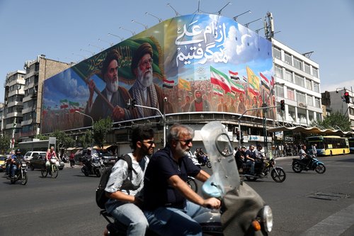 People ride past a billboard depicting the late leader of the Islamic Revolution, Ayatollah Ruhollah Khomeini, and the late Iran's Supreme Leader Ayatollah Ali Khamenei, on a street in Tehran, Iran, June 10, 2026.