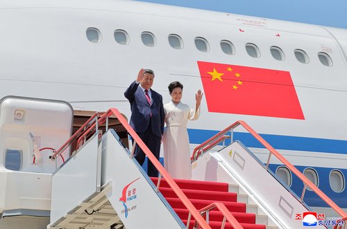 Chinese President Xi Jinping and his wife first lady Peng Liyuan disembark at Pyongyang Airport during Xi's state visit to Pyongyang, North Korea