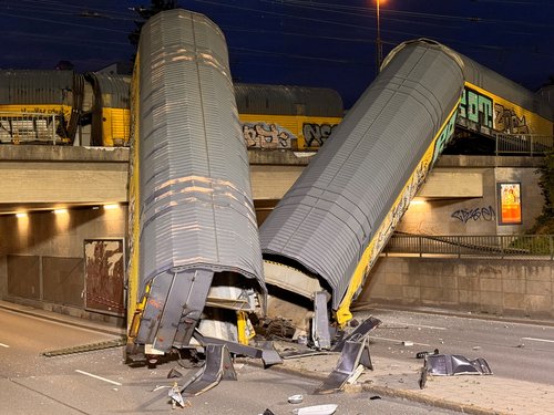 Two cars of a freight train which derailed after a collision, fell off a bridge and lay on a road in Munich, Germany, June 20, 2026. REUTERS/Christine Uyanik