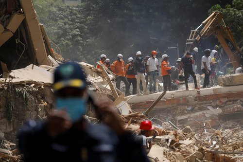 Emergency services work at the site of a collapsed building after earthquakes hit the country, in Caracas, Venezuela, June 25, 2026.