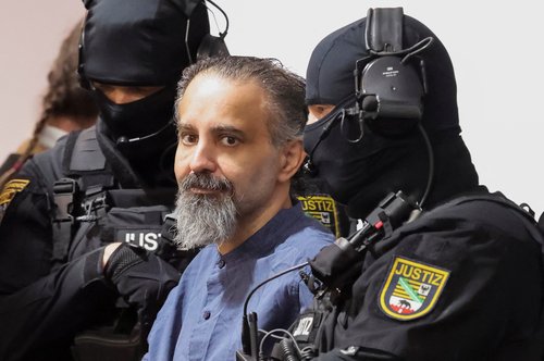 Suspect Taleb al-Abdulmohsen, a doctor from Saudi Arabia who faces charges of murder, attempted murder and dangerous interference with road traffic, looks on while being escorted by security officers as he attends his trial