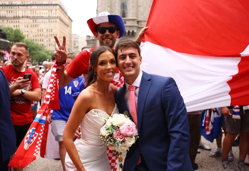 Newlyweds Ashton Ashby and Zachary Smith pose with Croatia fans REUTERS/Peter Cziborra