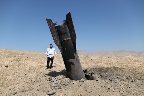 An Israeli ultra-Orthodox Jewish man reacts near a part of a missile protruding from the ground, following strikes from Iran, in the central Israeli-occupied West Bank, June 8, 2026.