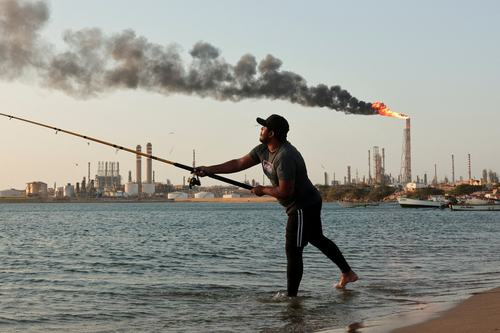 A man fishes near the Cardon refinery, part of the Paraguana Refining Center, as years of underinvestment, equipment failures and shortages have hampered fuel production in Venezuela, in Punta Cardon, Venezuela, May 6, 2026.