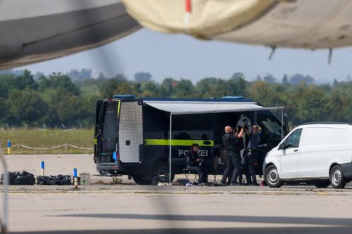 Police officers work in the vicinity of an Antonov cargo plane,. REUTERS/Axel Schmidt