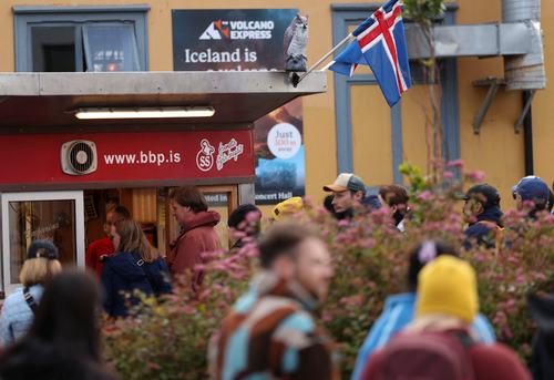 Tourists queue for a hot dog from Baejarins Beztu Pylsur stand ahead of a referendum on whether Iceland should resume accession negotiations with the European Union, in Reykjavik