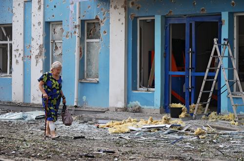 A woman walks past a bank building damaged during a Ukrainian overnight drone attack, according to local authorities, in the course of Russia-Ukraine conflict, in Belgorod, Russia August 9, 2026.