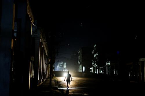 A man walks down a dark street as Cuba's electricity grid collapsed late on Sunday, plunging the island of about 10 million people into darkness as blackouts become more frequent, in Havana, Cuba August 3, 2026. REUTERS/Norlys Perez