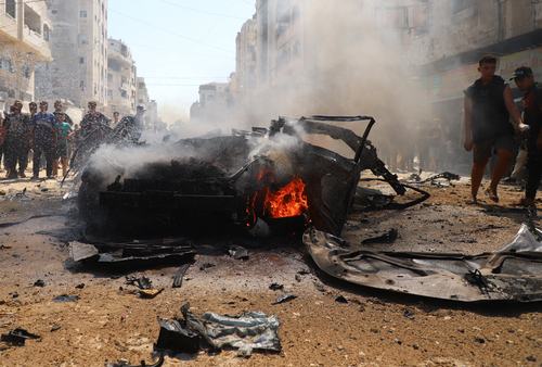 Residents attempt to extinguish a fire following an Israeli airstrike that hit a vehicle in Gaza City, August 31, 2026.