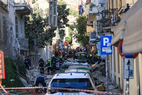 Emergency personnel work at the site where an old building partially collapsed. REUTERS/Louisa Gouliamaki