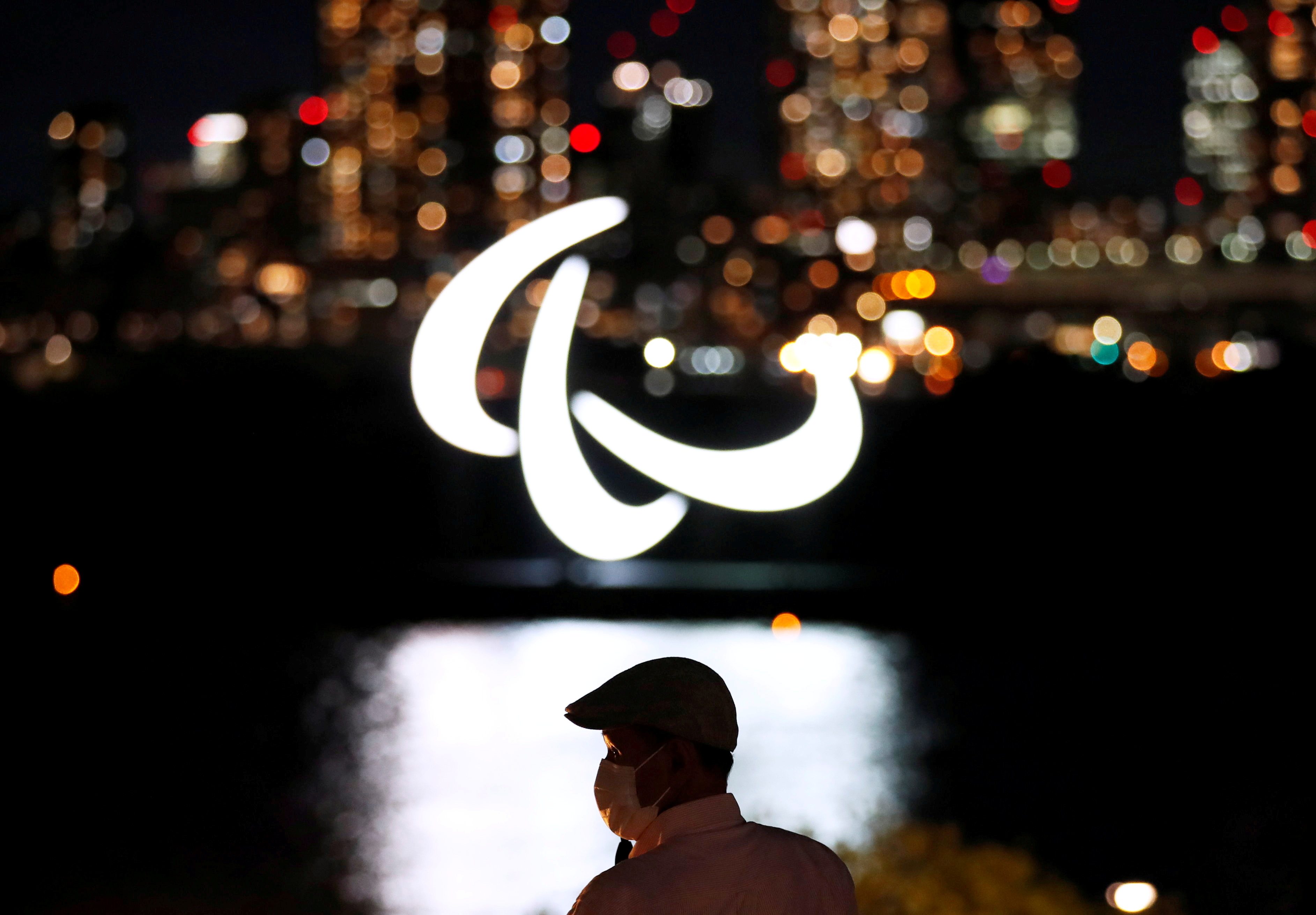 paraolimpijske igre, Visitor wearing looks at illuminated Paralympic symbol in Tokyo