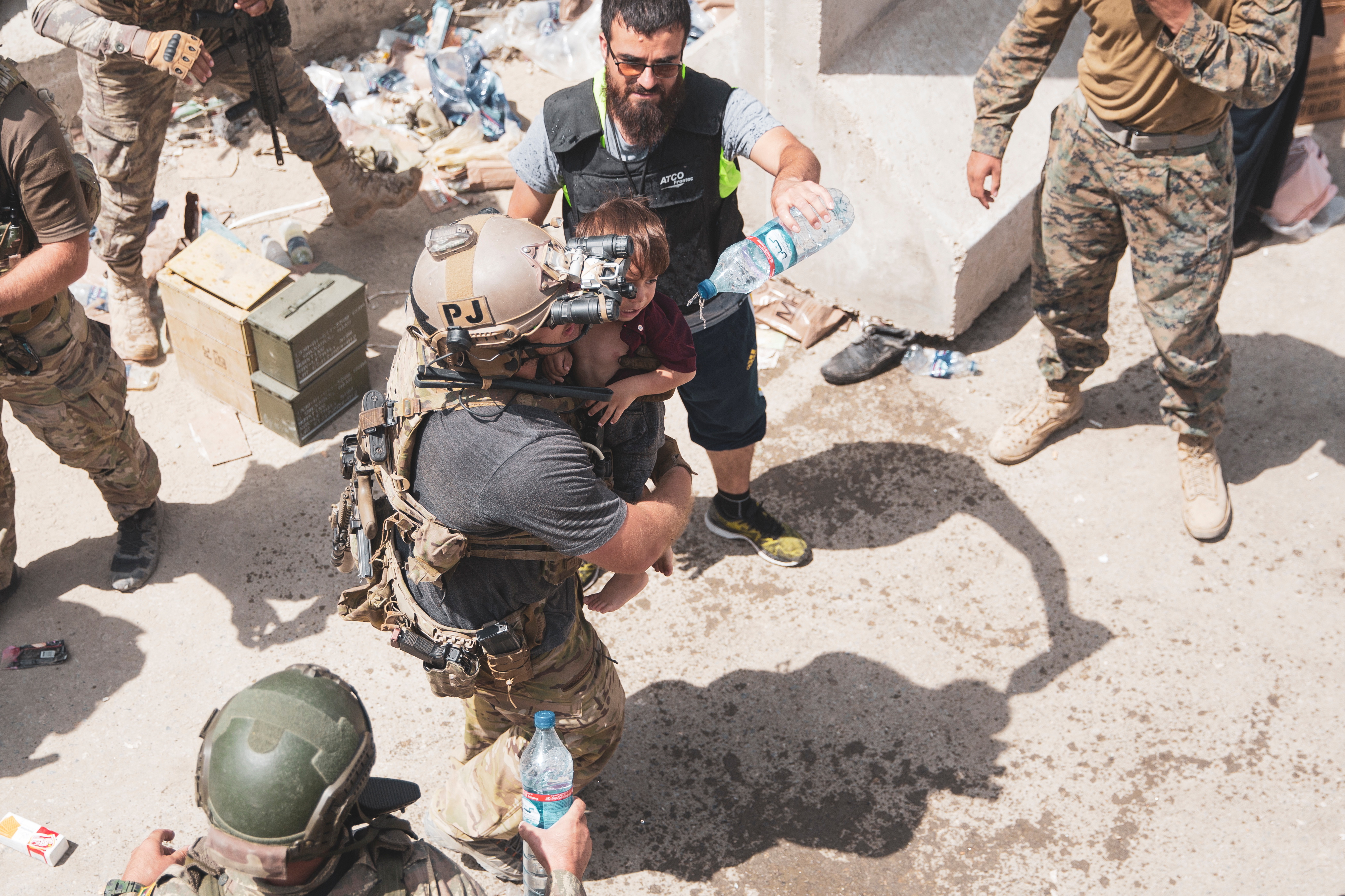 U.S. Airman carries a child at an Evacuee Control Checkpoint at Hamid Karzai International Airport, Kabul