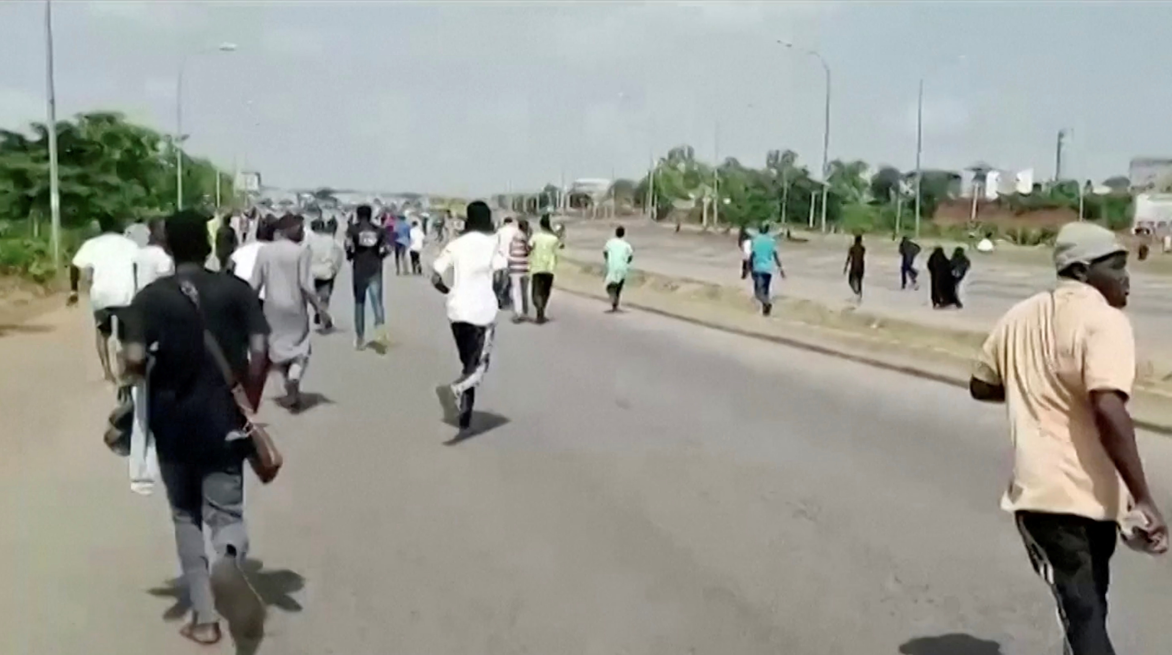 A screen grab shows people running during a protest in Abuja