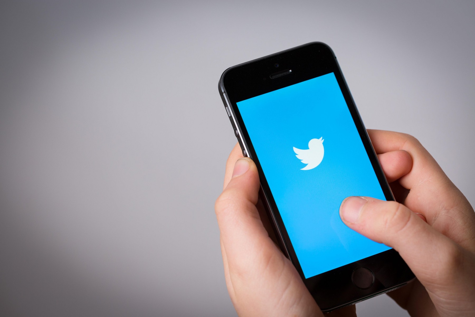 A teenage boy using Twitter on a mobile phone