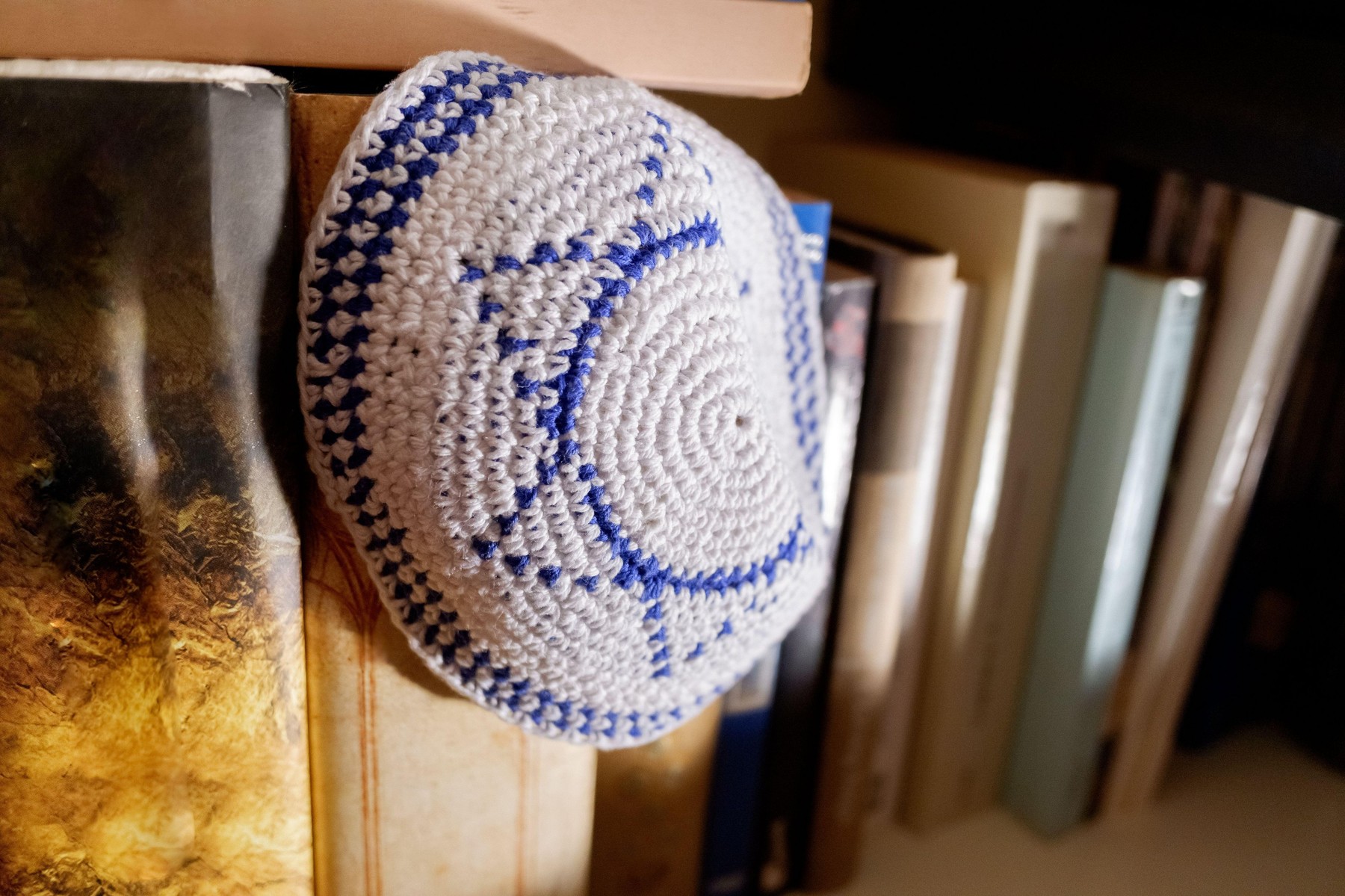 A jewish yarmulke with the star of david symbol of israel forgotten among old books.
