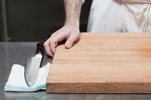 Close up of butcher with chopping board and knife